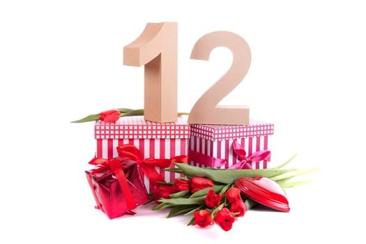 Number of age in a colorful studio setting with a red heart and gifts and tulips