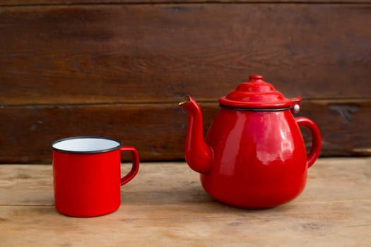 retro old vintage teapot and red cup in wooden background
