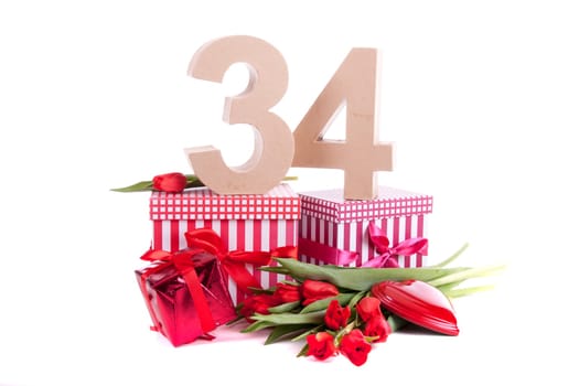 Number of age in a colorful studio setting with a red heart and gifts and tulips