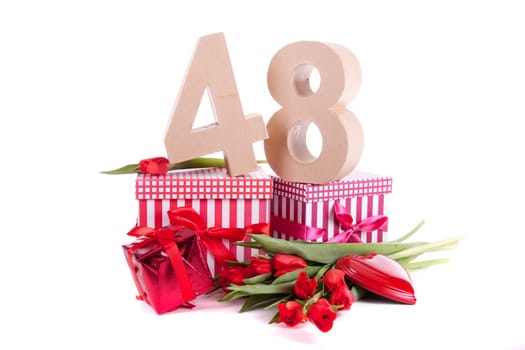 Number of age in a colorful studio setting with a red heart and gifts and tulips