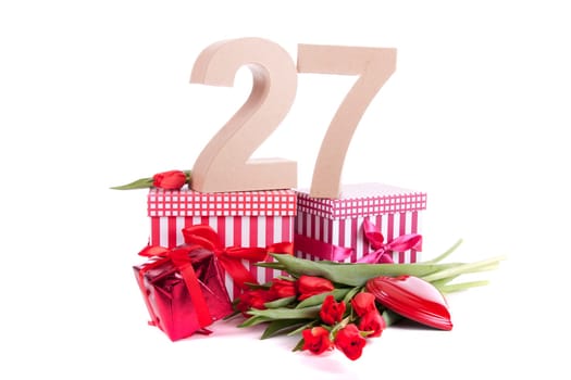 Number of age in a colorful studio setting with a red heart and gifts and tulips