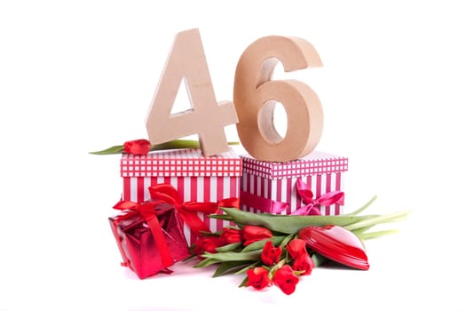 Number of age in a colorful studio setting with a red heart and gifts and tulips