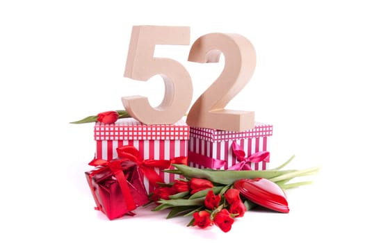Number of age in a colorful studio setting with a red heart and gifts and tulips