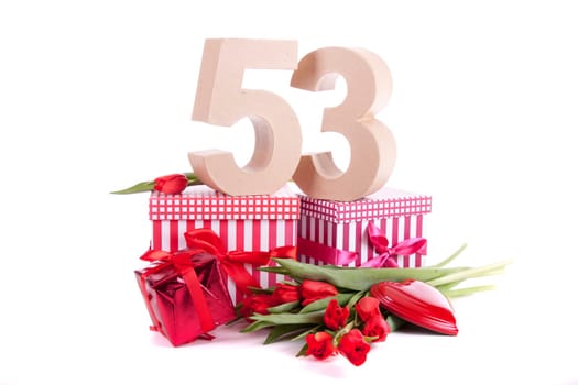 Number of age in a colorful studio setting with a red heart and gifts and tulips