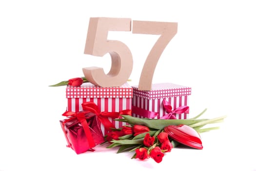 Number of age in a colorful studio setting with a red heart and gifts and tulips