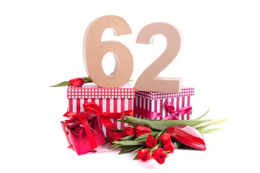Number of age in a colorful studio setting with a red heart and gifts and tulips