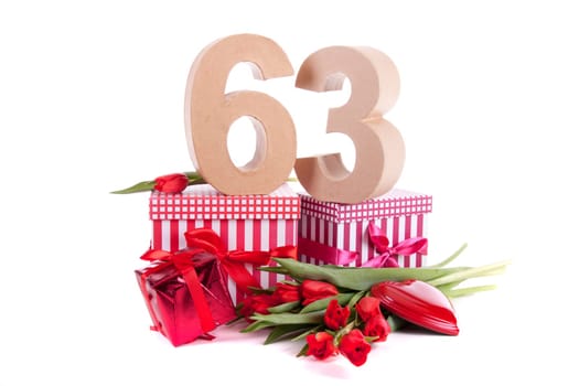Number of age in a colorful studio setting with a red heart and gifts and tulips