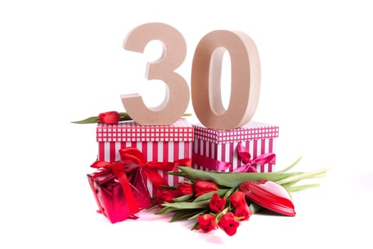 Number of age in a colorful studio setting with a red heart and gifts and tulips