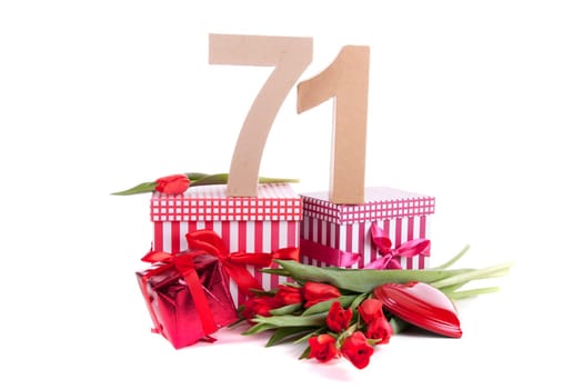 Number of age in a colorful studio setting with a red heart and gifts and tulips