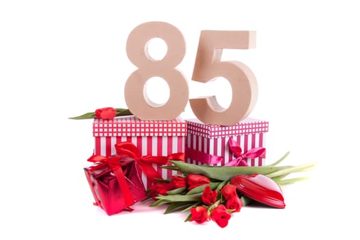 Number of age in a colorful studio setting with a red heart and gifts and tulips
