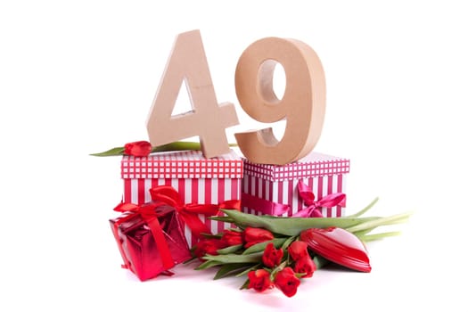 Number of age in a colorful studio setting with a red heart and gifts and tulips