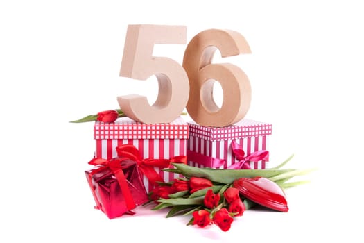 Number of age in a colorful studio setting with a red heart and gifts and tulips