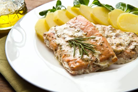 white dish with salmon fillet and potatoes