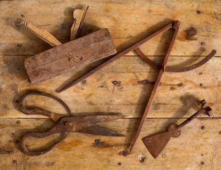 Aged rusted traditional tools wood planer wool scissors drawing compass on retro wood