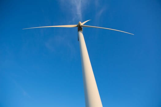 Aerogenerator windmills for green electric energy from below and ble sky background