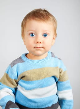 Closeup portrait of a sweet little adorable child over gray background.