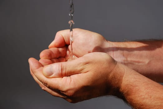 two male hands absorbing clear water