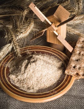 Wholemeal flour and wheat on cloth sack, close-up