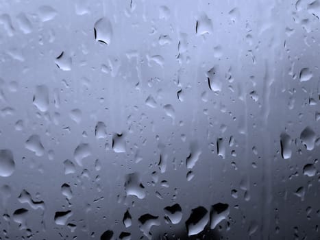 Raindrops on a window on a cloudy day