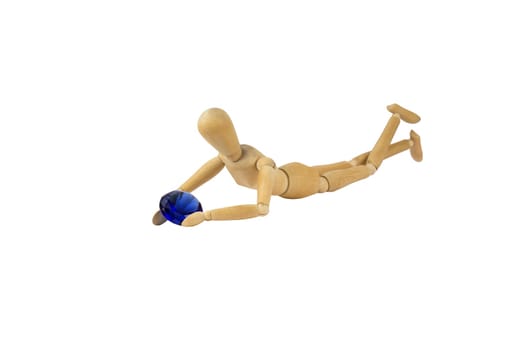 A wooden female doll is holding a blue diamond