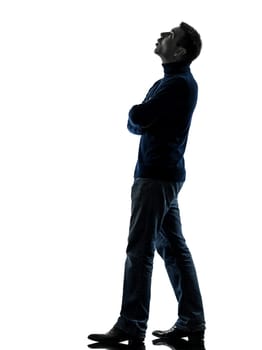 one caucasian man looking up pensive  full length in silhouette studio isolated on white background