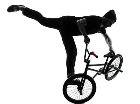 one caucasian man exercising bmx acrobatic figure in silhouette studio isolated on white background