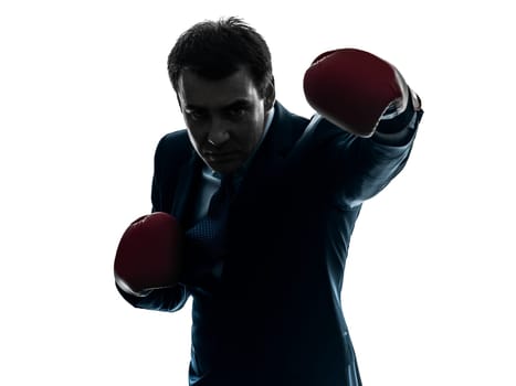one caucasian businessman with boxing gloves   in silhouette studio isolated on white background