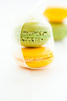 Closeup of yellow and green macaroons against light background