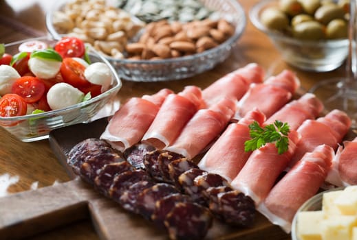 Full table of prosciutto, olives, cheese, and salad