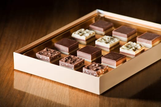 Assorted chocolate candies in a box close up