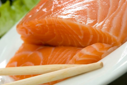 sliced salmon steak with chop-sticks close up shoot