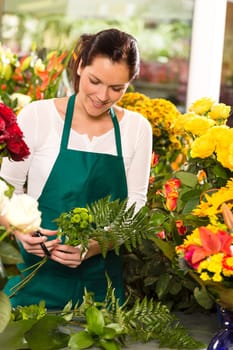 Young florist preparing flowers bouquet shop store smiling colorful