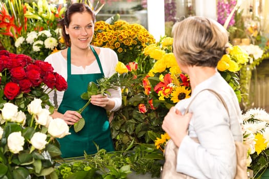 Young woman arranging flowers shop market selling customer smiling