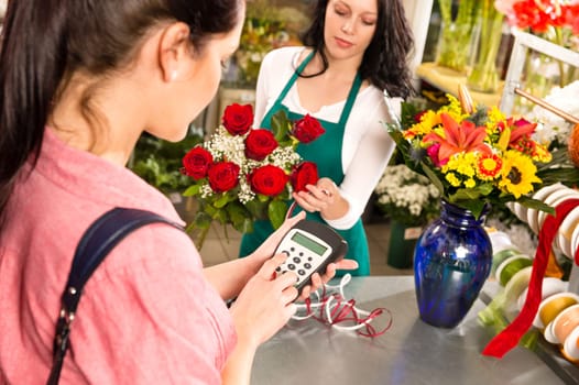 Woman customer paying flowers shop credit card florist roses