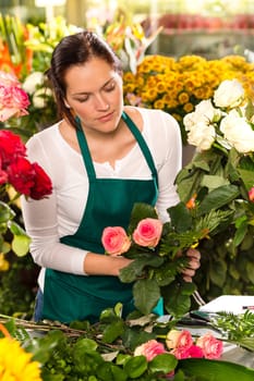 Woman florist preparing bouquet flowers shop retail arranging