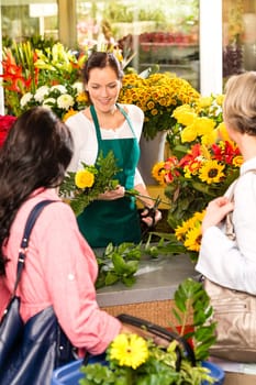 Young woman florist cutting flower shop customers retail colorful