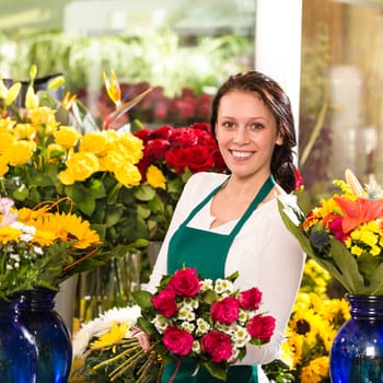 Cheerful female florist bouquet roses flower shop posing owner