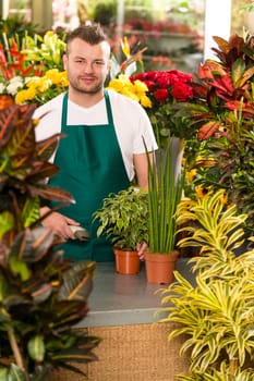 Young man scanning barcode flower shop gardening florist