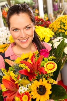 Smiling florist woman colorful bouquet flower market showing sunflower