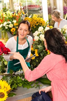 Young florist ordering roses woman customer flower market retail shop