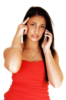 A teenage girl on the cell phone getting a very bad news and is worried, in a strapless red dress and long black hair for white background.