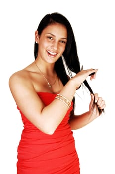 A beautiful teen girl with a scissor in her hand, smiling and cutting her nice long black hair, for white background.