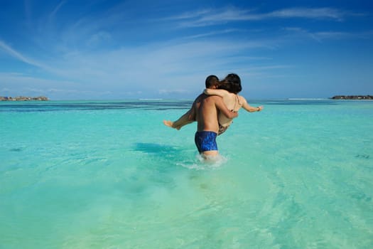 happy young asian couple enjoying summer and have on beautiful white sand beach