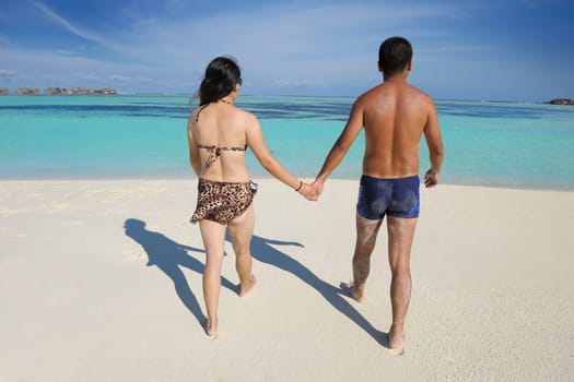 happy young asian couple enjoying summer and have on beautiful white sand beach