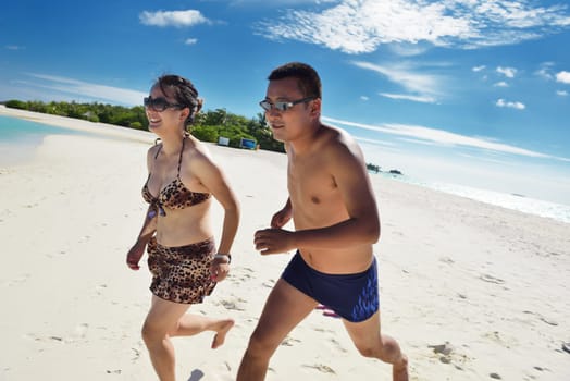 happy young asian couple enjoying summer and have on beautiful white sand beach