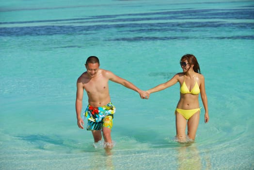 happy young asian couple enjoying summer and have on beautiful white sand beach