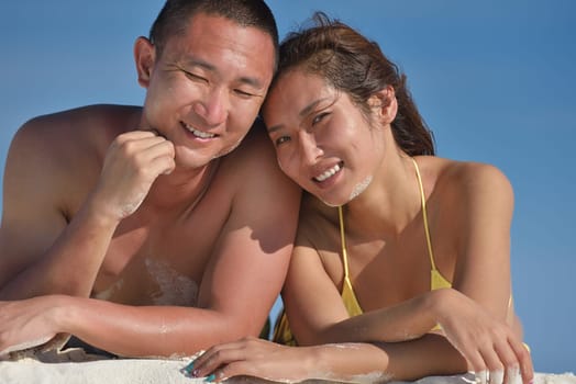happy young asian couple enjoying summer and have on beautiful white sand beach