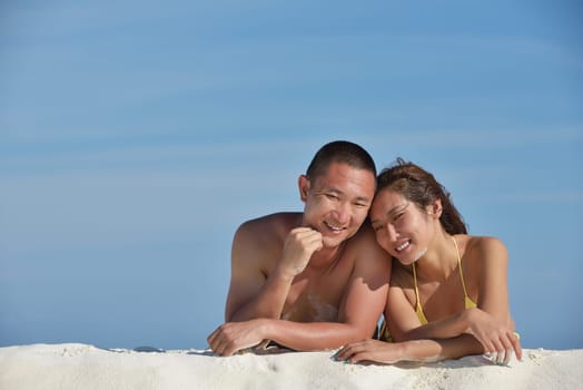 happy young asian couple enjoying summer and have on beautiful white sand beach