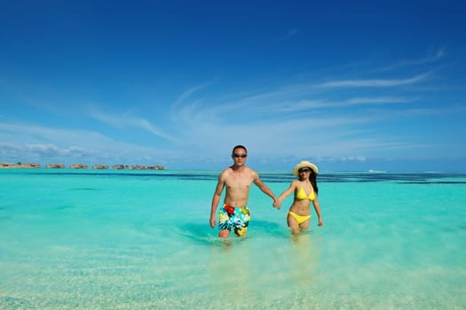 happy young asian couple enjoying summer and have on beautiful white sand beach