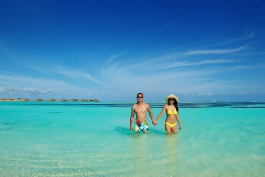 happy young asian couple enjoying summer and have on beautiful white sand beach